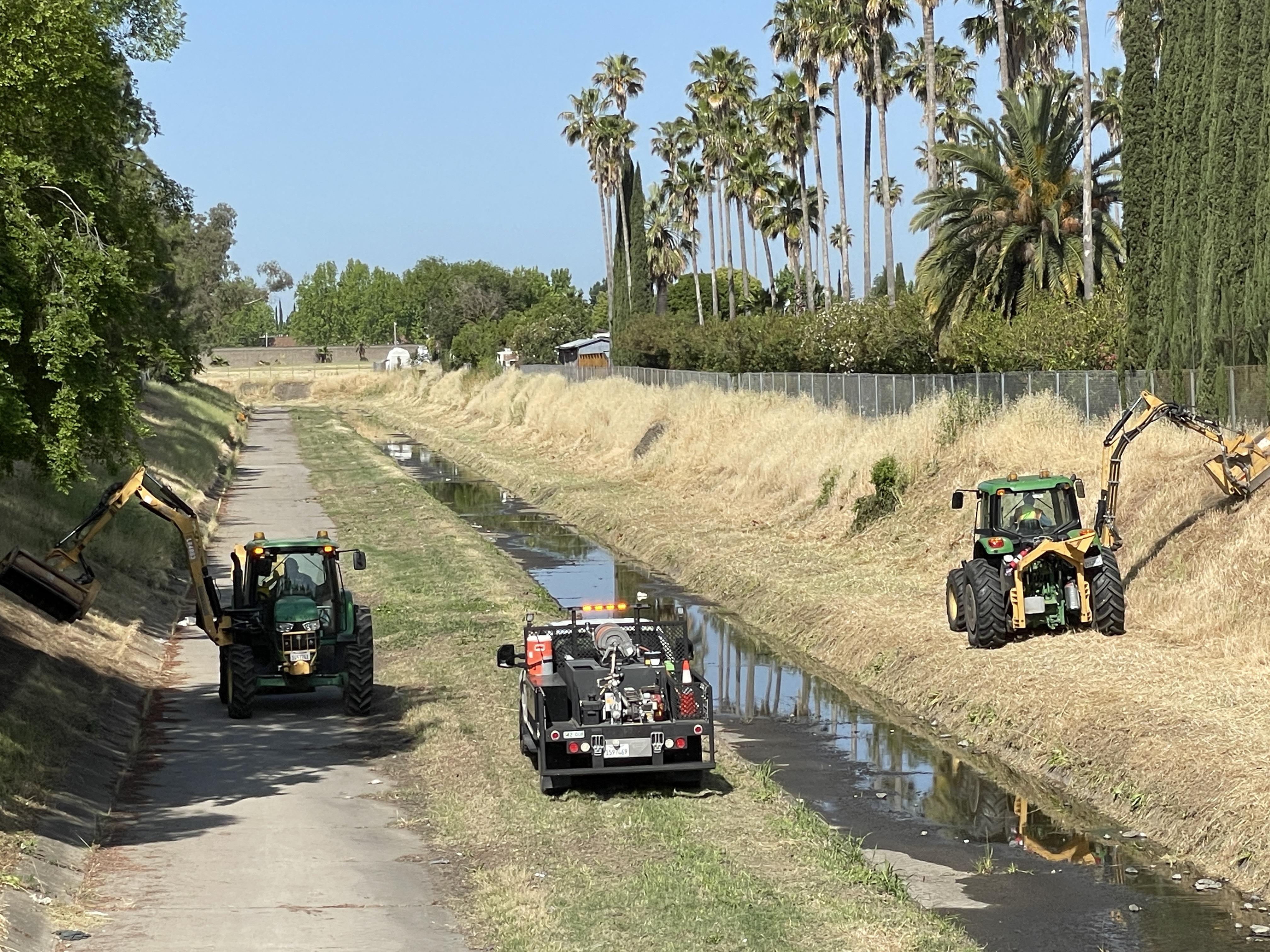 Crews mowing drainage area 