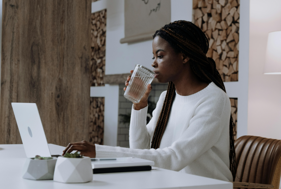 Woman at desk drinking water